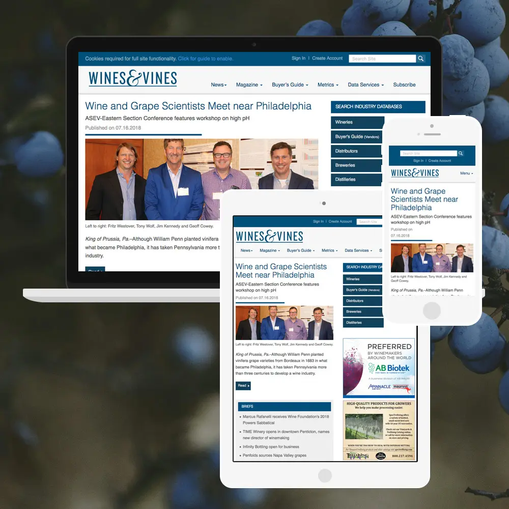A variety of laptop, tablet, and smartphone screens showing the Wines&Vines website